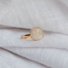 Magical moonstone with its iridescent flashes truly comes to life with our Calypso Ring. A subtle moon face shines through this gem. Moonstone is known for activating your intuitive power of feminine energy. The energy of moonstone can invite creativity, balance, and protection. Although our metals can withstand water, avoid getting your moonstone wet for stone longevity. - Made with 14k gold filled material - 10mm moonstone gem set on our 12ga Eternity Band Please note: You may experience a sli Moon Face Ring, Face Ring, Moon Face, Quartz Ring, Eternity Band, The Energy, Feminine Energy, Eternity Bands, Moonstone