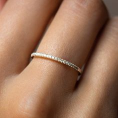 a woman's hand with a diamond ring on her left hand and the middle finger