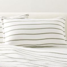 a white bed with two pillows on top of it