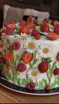 a cake decorated with strawberries and daisies