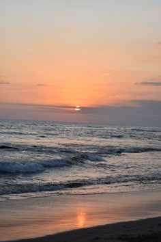 the sun is setting over the ocean with waves