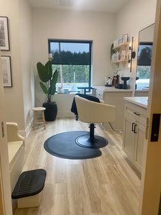 a hair salon with chairs, tables and plants in the window sill on the far wall