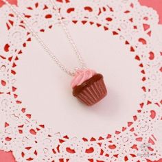 Chocolate and strawberry is a combination that is so delicious, it borders on divine. When you treat yourself to the Scented Strawberry Chocolate Cupcake Necklace, you can surround yourself with these two delicious fragrances and add a splash of color to any ensemble. Carefully handmade to resemble a chocolate cupcake topped with mouthwatering strawberry icing, the pendant is fashioned out of eco-friendly polymer clay. The luscious mix of chocolate and strawberry scents come from fragrance oils Scented Jewelry, Cupcake Jewelry, Hands Jewelry, Strawberry And Chocolate, Chocolate Jewelry, Strawberry Icing, Candy Charms, Cupcake Necklace, Tiny Foods