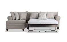 a sectional couch with pillows and a pull out bed underneath the chaise longue