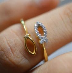 a woman's hand holding a gold and diamond ring