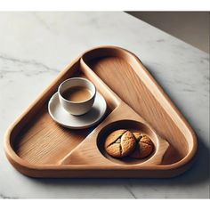 a wooden tray with two cookies and a cup of coffee on it next to a white marble countertop