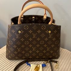 Lv Montaigne Mm. Measures 14” X 9” X 5.5”. Purse Is In Great Shape. Please Note It Does Not Come With A Key Bell Only One Lock & 2 Keys. Handles Are In Great Shape. No Wear On The Corners And The Inside Is Clean. No Odors Or Stains. Comes From A Smoke Free Home. Strap Is 29.5” Long. If You Would Want To Wear This As A Crossbody, You Would Need To Switch Straps. Designer Brown Bag With Original Box, Brown Monogram Canvas Satchel With Top Carry Handle, Brown Monogram Canvas Satchel With Top Handle, Louis Vuitton Montaigne Mm, Brown Monogram Canvas Satchel With Detachable Handle, Brown Signature Coated Canvas Top Handle Satchel, Office Satchel With Gold-tone Hardware And Monogram Canvas, Formal Brown Monogram Canvas Satchel, Elegant Monogram Canvas Satchel For Office