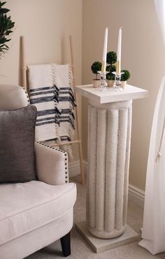 a white table with candles on it next to a chair