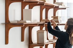 a woman standing in front of a wall filled with books