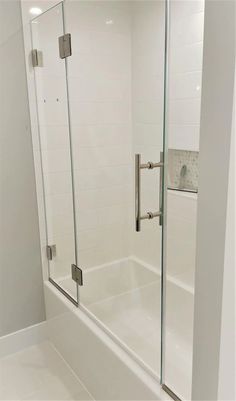 a white bathroom with a glass shower door