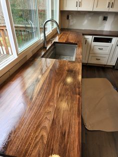 a wooden counter top in a kitchen next to a window