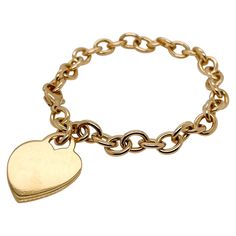 A very fine Tiffany & Co. bracelet. In 18k gold. With slightly oval links and a heart-shaped pendant charm. The charm is not engraved. Simply wonderful, classic Tiffany design! Date: 20th Century Overall Condition: It is in overall good, as-pictured, used estate condition with some very fine & light surface scratches and other signs of expected light wear consistent with age. Fineness: Marked 750 for 18k gold fineness. Marks: Tiffany & Co. / 750 Measurements: Length: ca. 7 1/2 in Pendant Width: Tiffany Charm Bracelet, Tiffany And Co Bracelet, Dog Chain, Vintage Charm Bracelet, Bracelet Heart, Tiffany And Co, Heart Bracelet, Chain Link Bracelet, Tiffany & Co.