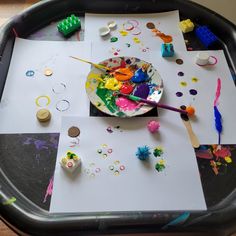 an art tray with paint, paper and other crafting supplies on it for kids to make