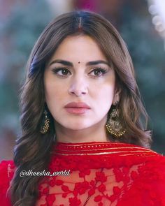 an image of a woman in red dress looking at the camera with serious look on her face