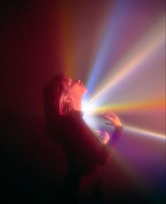 a woman standing in front of a colorful light