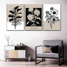 three black and white paintings on a wall in a living room with a gray chair