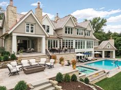 a large house with a pool in the front yard and an outdoor living area next to it