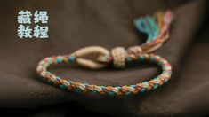 the bracelet is decorated with multicolored rope and has a tassel on it