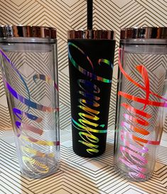 three different colored tumblers sitting next to each other