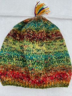 a multicolored knitted hat with a tassel