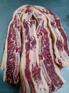 several pieces of raw meat sitting on top of a table