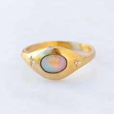 Our Orbit signet style ring has been set with a black opal from Lightning Ridge with two star set diamonds either side. Opals are the birthstone of October. Opal measures 7 x 5 mm. F/VS Diamonds total weight 0.01ct. Band width at back 2.2 mm Please note, we will match the opal as close to the image as possible. Each opal is unique and may vary in appearance and colour from what is depicted on the site. Luxury Vintage Opal Ring Gift, Diamond Star Ring, Opal Signet Ring, Non Diamond Rings, Sarah Gardner Jewellery, Lost Wax Casting Rings, Eclipse Ring, Sarah Gardner, Opal Gold Ring