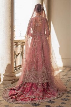 the back of a woman's wedding dress in pink