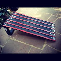 four skis sitting on top of a wooden sled next to a potted plant