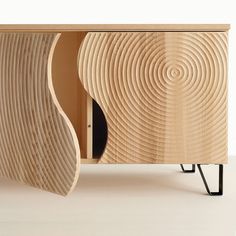 a wooden cabinet with an interesting design on the front and side panels that look like waves