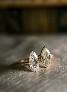 two engagement rings sitting on top of a table