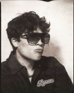 a black and white photo of a young man wearing sunglasses with the word ronson on it