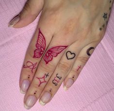 a woman's hand with tattoos on it and a butterfly tattoo on the ring finger