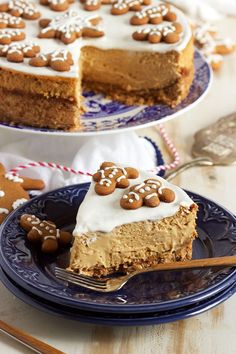 a piece of cake with white frosting and gingerbreads on top is sitting on a blue plate