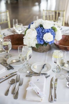 the table is set with silverware and flowers