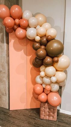 the balloon arch is decorated with peach, white and brown balloons for a modern look