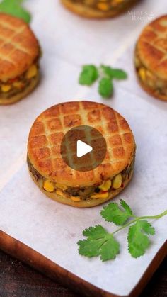 mini waffle sandwiches with corn and cheese are on top of a cutting board, ready to be eaten