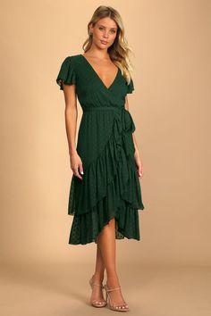 a woman is wearing a green dress with ruffles on the skirt and heels