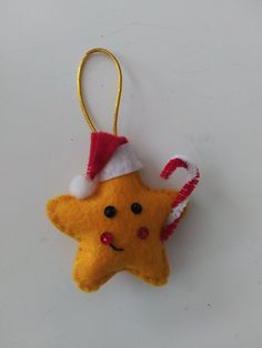 a yellow star ornament with a red santa hat on it's head