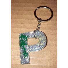 the letter p is made out of metal and has green paint splattered on it