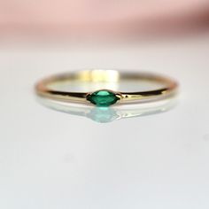 A dainty marquise emerald is at the center of our "Wink" ring, giving you just a little wink of sparkle!   - Marquise stone measures 4mm x 2mm - Handcrafted out of solid 10K or 14K gold - Round band measures 1.2mm in width - This emerald is lab made Processing Times -  Current processing time is 1 - 3 weeks.  Each Item is handmade to order with love and care! In Stock Items -  Contact Liesel Love with any rush order questions, or to see if we have anything ready made and in stock.  Returns -  Li Green Marquise Emerald Rings, Marquise Emerald Ring For Promise In May, Emerald Marquise Promise Ring For May Birthstone, Green Marquise Cut Emerald Ring, Emerald Marquise Ring For May Birthstone, Green Marquise Emerald Ring For Anniversary, Marquise Emerald Ring For May Birthstone, Marquise Emerald Ring In Yellow Gold, Elegant Marquise Emerald Ring