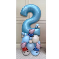 the balloon is shaped like a number two with peppo and piggy figures on it