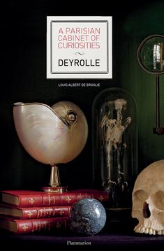 there is a skull and some books on the shelf next to each other with a sign that says, a persian cabinet of curioies deyrollie