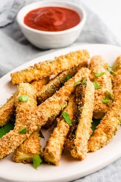 keto baked zucchini fries on a white plate with green garnish