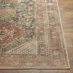 an antique persian rug is on the floor with wood floors and hardwooding in the background