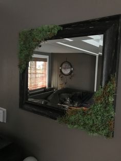 a mirror that has moss growing on the side of it and a clock in the background