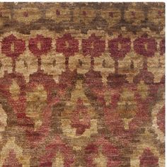 an old rug with red and beige designs on the bottom, along with brown and tan colors