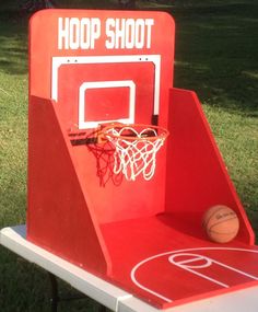 an outdoor basketball hoop set up in the grass with a basketball on it's backboard