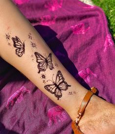 a woman's arm with two butterflies on it, and stars in the sky