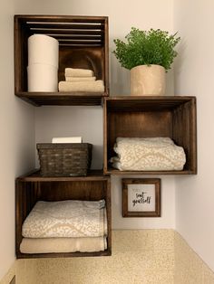 three wooden shelves holding towels and other items