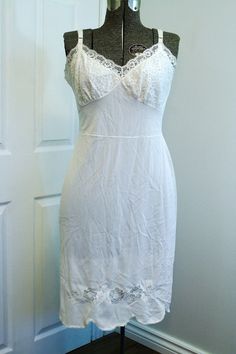 Gorgeous white full dress slip made by Reitman's - "Where smart women shop." Lovely lace cups, tulle trim on upper back, scalloped hem with simple lace trim, and floral lace decoration above hem on front. Adjustable straps with metal hardware. Condition: very good. Has a couple of spots of minor wear on the lower back and left back skirt, as well as two tiny faint darkish marks on the back, see last three photos. Size: approximately a modern size medium. This size is provided only as a guide; pl Fitted Lace Slip Dress With Lace Back, Fitted Lace Back Slip Dress, Sleeveless Lace Slip Dress With Lace Back, Sleeveless Lace Back Slip Dress, Fitted Lace Dress With Lace Trim For Summer, Lace Wedding Night Slip Dress With Lace Back, Wedding Night Slip Dress With Lace Back, Fitted Slip Dress With Lace Trim And Spaghetti Straps, Fitted Camisole Dress For Wedding Night